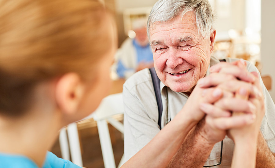 A caregiver laughing with a dementia patient​