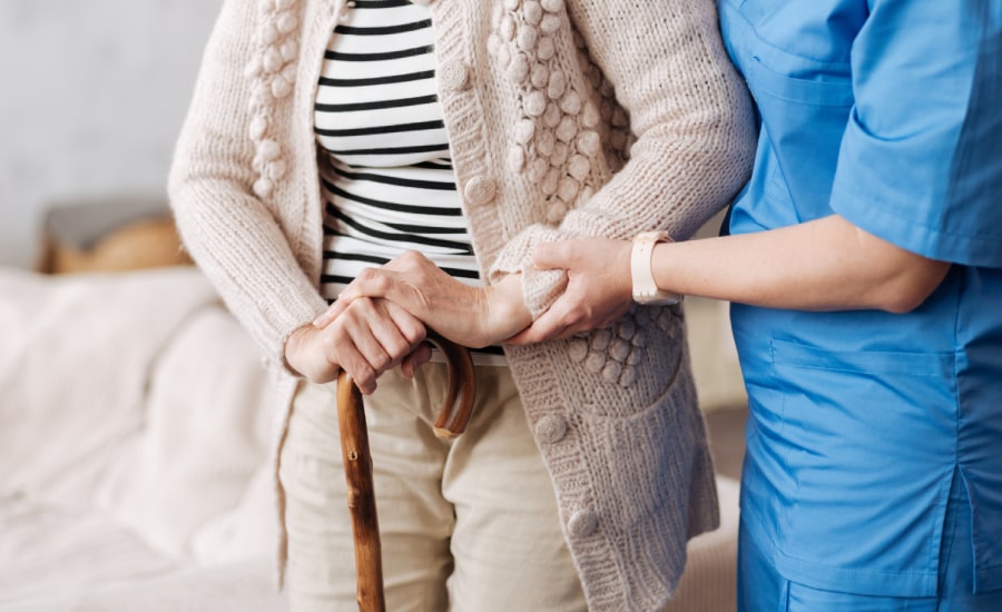 A caregiver assisting an elderly woman​