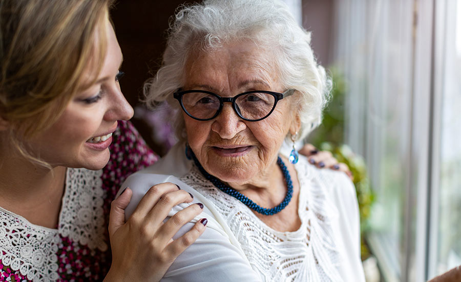 A family caregiver smiling at her senior loved one​