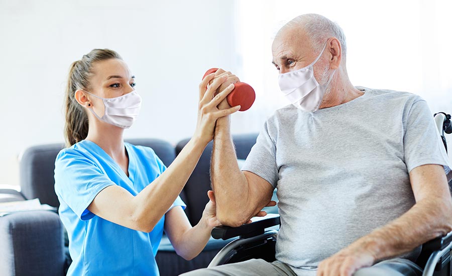 A nurse helping an elderly man exercise​