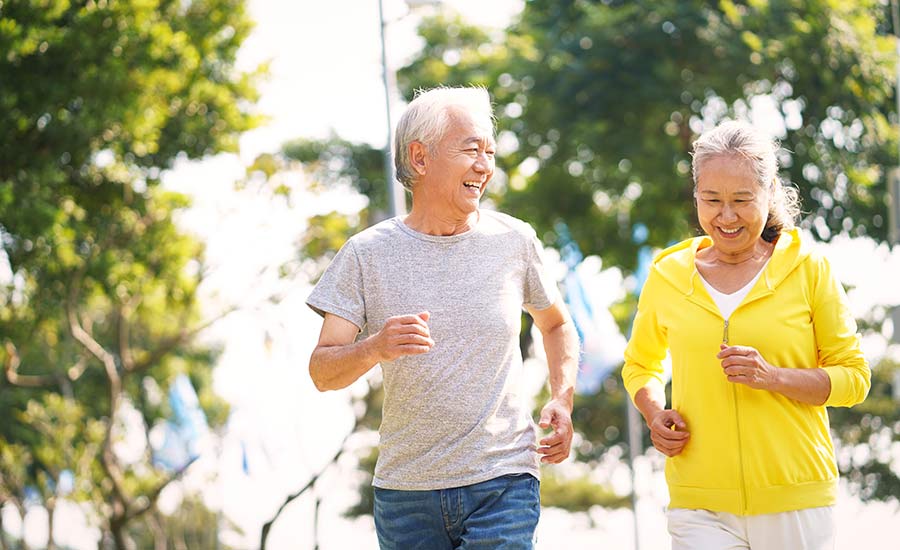 An elderly couple running in the park​