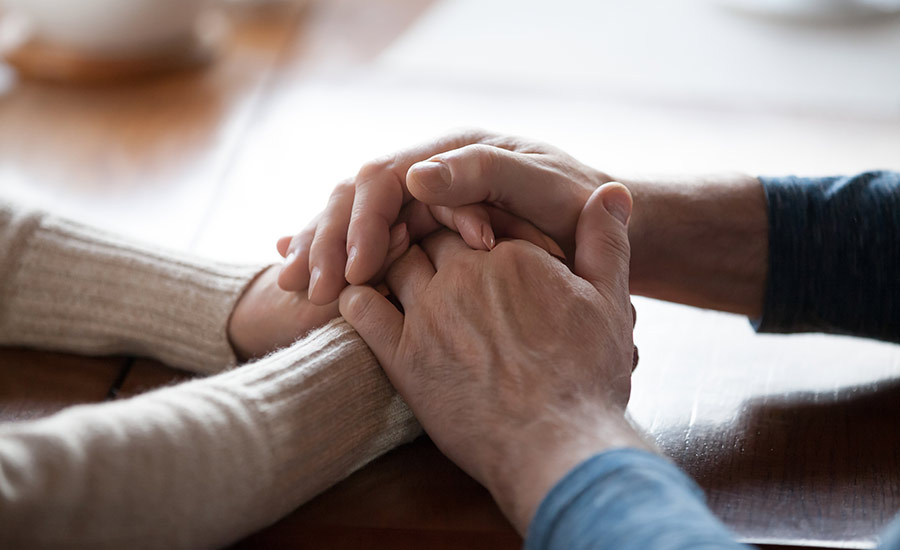 A senior holding a caregiver's hand​