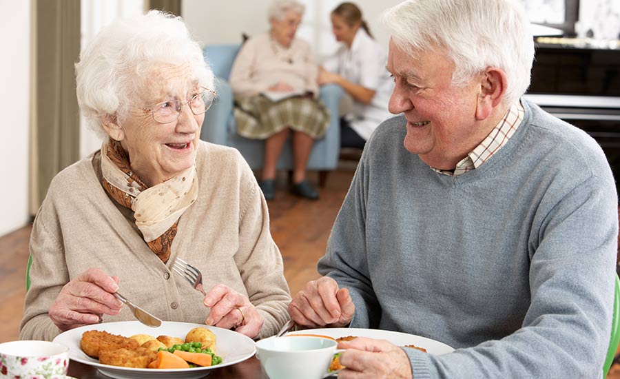 An elderly couple having a meal together​