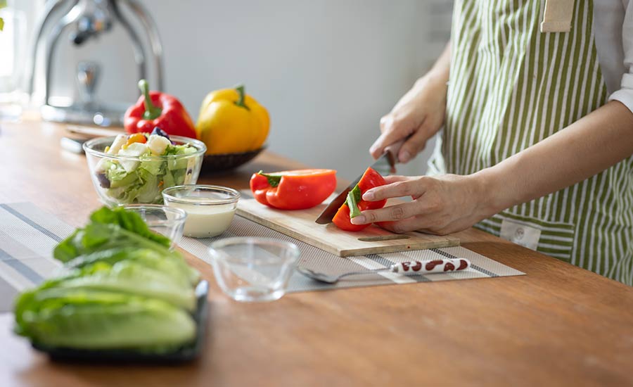 An elderly individual chopping vegetables​