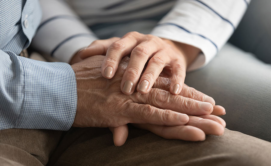 An elderly couple holding hands​