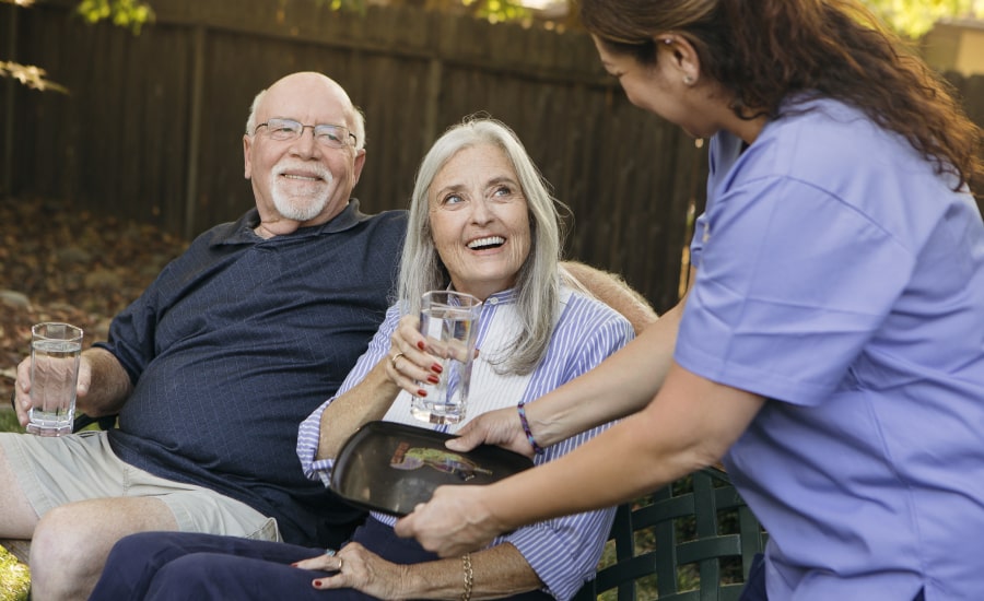 Elderly couple with attentive caregiver