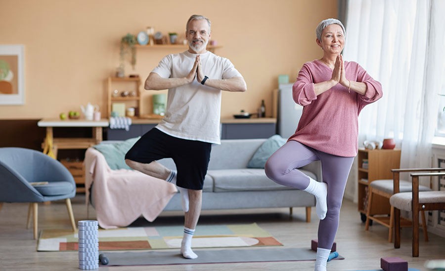 A senior couple exercising in their living room​