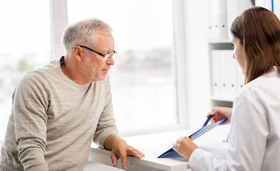 An elderly man talking to a healthcare professional​