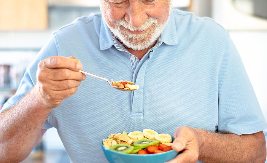 An elderly man eating a healthy bowl of fruits​