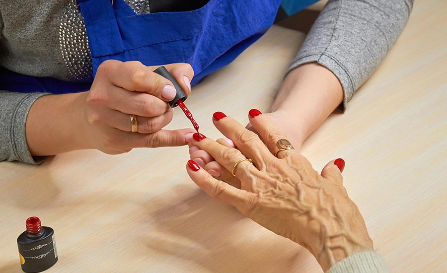 An elderly woman getting a manicure