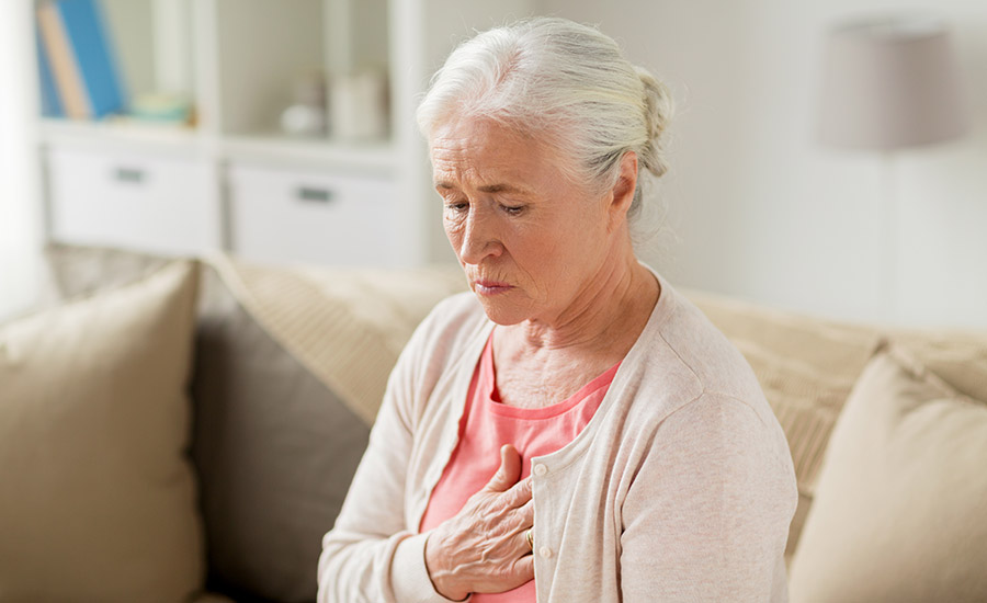 An elderly woman holding her chest