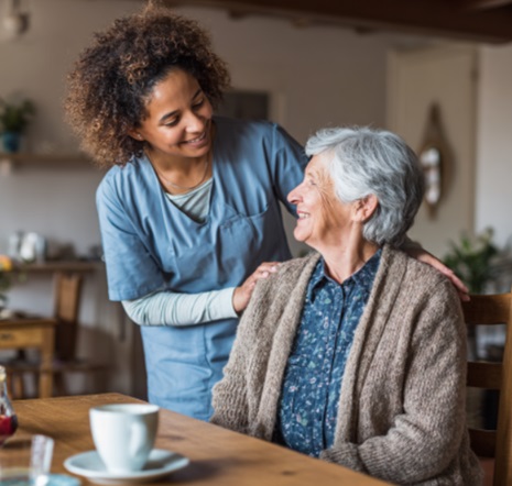 Caregiver sharing supportive conversation with senior woman at home in Madison, WI.