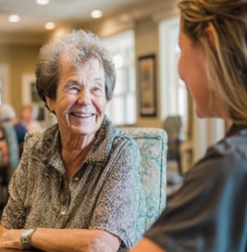 Senior woman smiling during supportive conversation with caregiver in Fitchburg, WI.